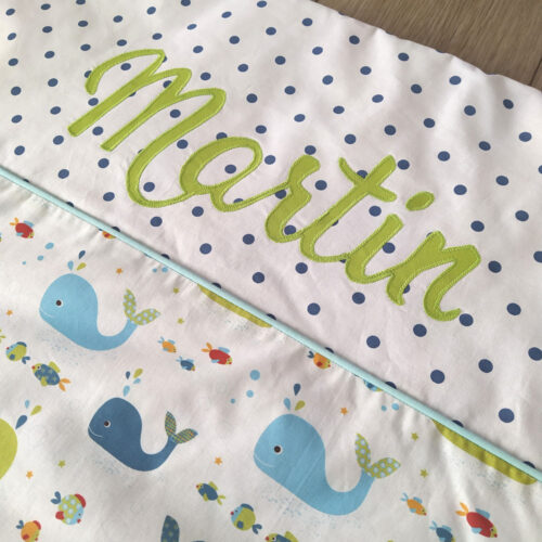 couverture pour bébé garçon personnalisé avec le prénom martin au tons vert et bleu, tissu blanc à pois bleu et tissu blanc à motif marrin avec des baleines et de poissons colorés une création 2 Pommes et un mammouth