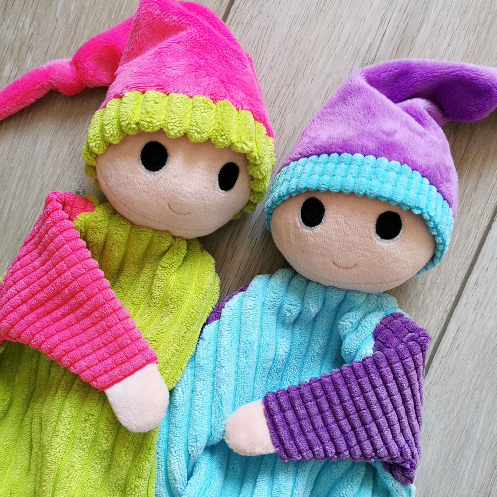 deux doudous lutins patati pour bébé fabriqués en france de manière artisanale, l'un vert pomme et rose fuchsia, l'autre bleu turquoise et violet, ils sont côte à côte et posés sur un fond en bois, une création 2 pommes et un mammouth