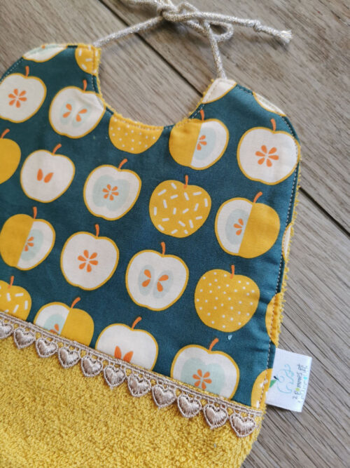 petit bavoir pour les premiers repas de bébé, bi matière, une éponge de coton jaune moutarde et un tissu coton enduit vert avec des pommes jaunes, une petite dentelle vient réhaussée l'ensemble, une création 2 pommes et un mammouth