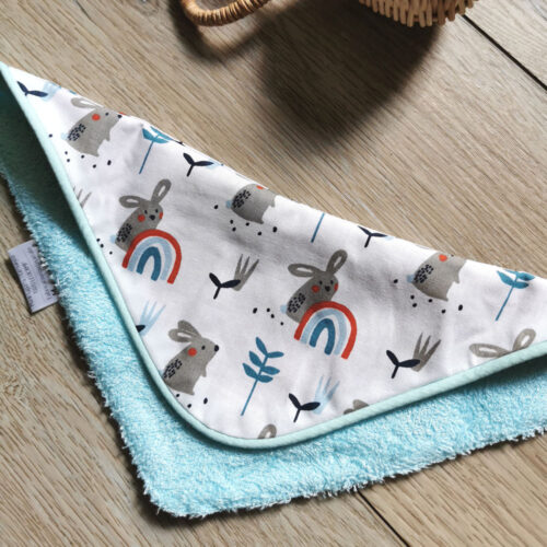 bavoir badana réversible très absorbant pour bébé garçon, en tissu éponge bleu ciel et tissu éponge bleu turquoise et tissu coton blanc avec des petits lapins et des petits arc-en-ciel bleu et rouge, une création 2 pommes et un mammouth