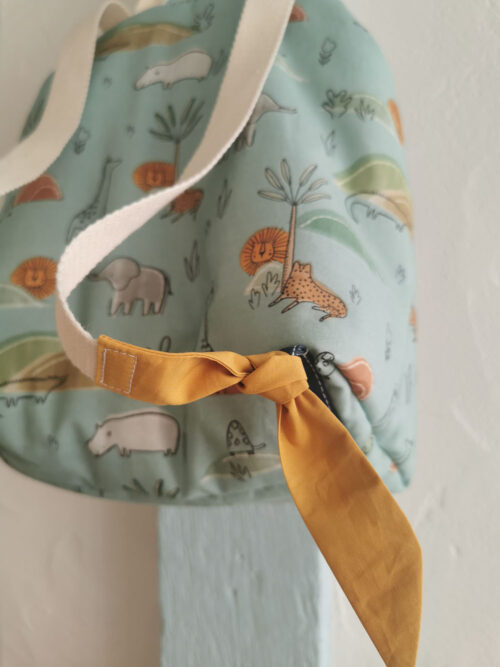 sac à dos bébé, créche ou maternelle personnalisable, bleu avec des animaux de la savane, des couleurs lumineuses et tendres. Sac conçu pour développer l'autonomie de l'enfant, fabriqué à la main de manière artisanale, made in france, made in cantal, une création 2 pommes et un mammouth