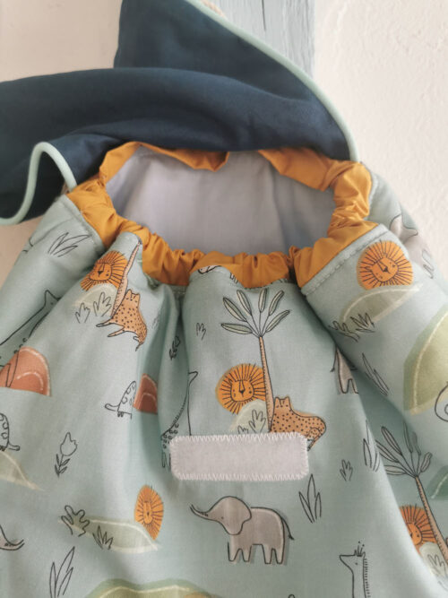 sac à dos bébé, créche ou maternelle personnalisable, bleu avec des animaux de la savane, des couleurs lumineuses et tendres. Sac conçu pour développer l'autonomie de l'enfant, fabriqué à la main de manière artisanale, made in france, made in cantal, une création 2 pommes et un mammouth