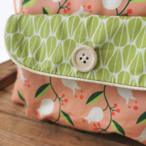 sac à dos maternelle personnalisable, orange avec des fleurs et vert avec des feuilles, des couleurs lumineuses et tendres. Sac conçu pour développer l'autonomie de l'enfant, fabriqué à la main de manière artisanale, made in france, made in cantal, une crétation 2 pommes et un mammouth