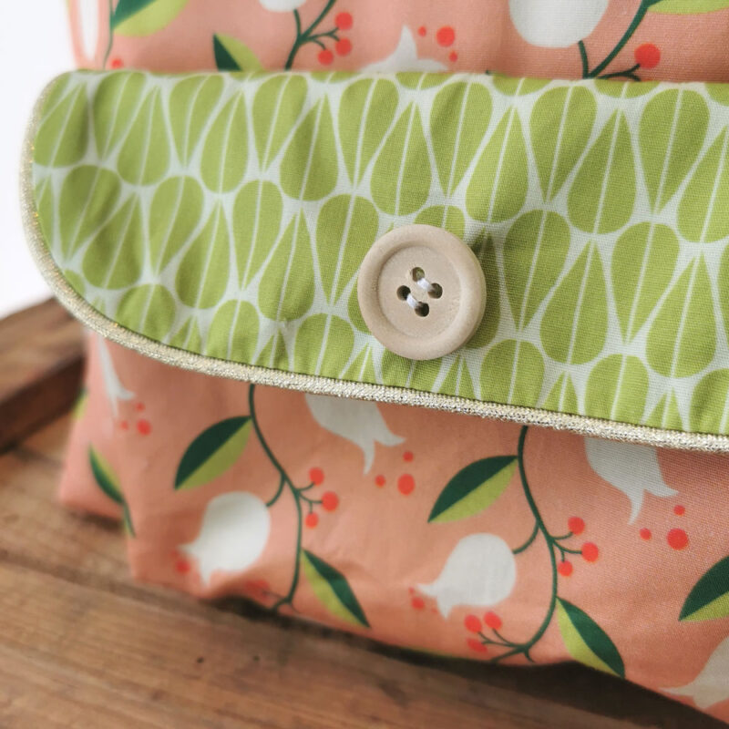 sac à dos maternelle personnalisable, orange avec des fleurs et vert avec des feuilles, des couleurs lumineuses et tendres. Sac conçu pour développer l'autonomie de l'enfant, fabriqué à la main de manière artisanale, made in france, made in cantal, une crétation 2 pommes et un mammouth