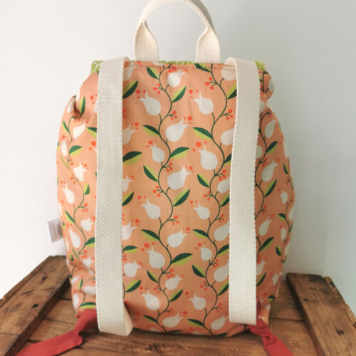 sac à dos maternelle personnalisable, orange avec des fleurs et vert avec des feuilles, des couleurs lumineuses et tendres. Sac conçu pour développer l'autonomie de l'enfant, fabriqué à la main de manière artisanale, made in france, made in cantal, une crétation 2 pommes et un mammouth