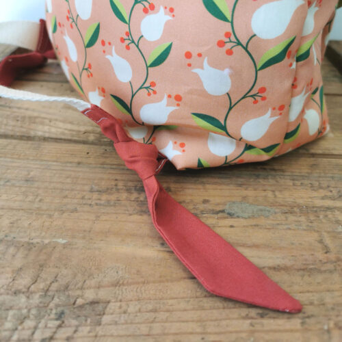 sac à dos maternelle personnalisable, orange avec des fleurs et vert avec des feuilles, des couleurs lumineuses et tendres. Sac conçu pour développer l'autonomie de l'enfant, fabriqué à la main de manière artisanale, made in france, made in cantal, une crétation 2 pommes et un mammouth