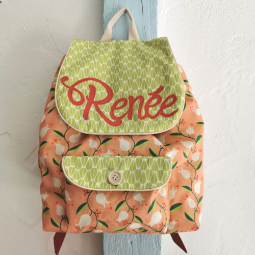 sac à dos maternelle personnalisable, orange avec des fleurs et vert avec des feuilles, des couleurs lumineuses et tendres. Sac conçu pour développer l'autonomie de l'enfant, fabriqué à la main de manière artisanale, made in france, made in cantal, une crétation 2 pommes et un mammouth