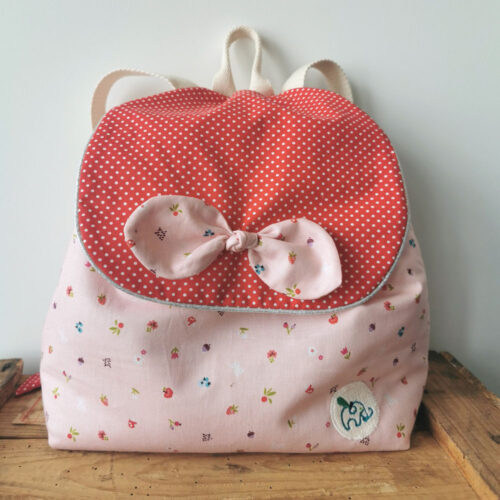 sac à dos bébé, créche ou maternelle rose et rouge . Sac conçu pour développer l'autonomie de l'enfant, fabriqué à la main de manière artisanale, made in france, made in cantal, une crétation 2 pommes et un mammouth