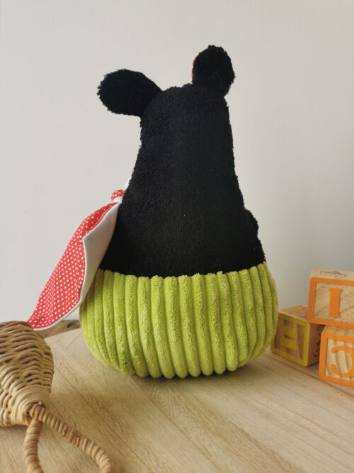 gros dodu noir, à la culotte vert pomme, aux joues blanche et aux oreiles rouges posé debout sur une plaque en bois, une création 2 pommes et un mammouth