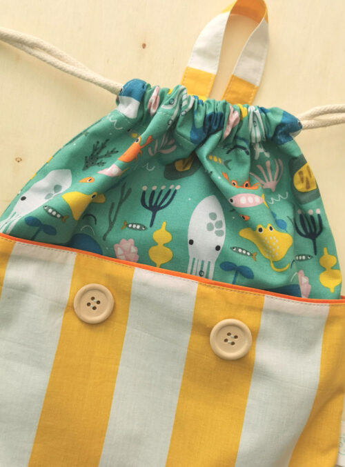 sac à dos ficelle pour enfant fabriqué à la main de façon artisanale, made in france, aux couleurs acidulées jaune, bleu et orange et des motifs poissons, crabes et calamars , une création 2pommes et un mammouth