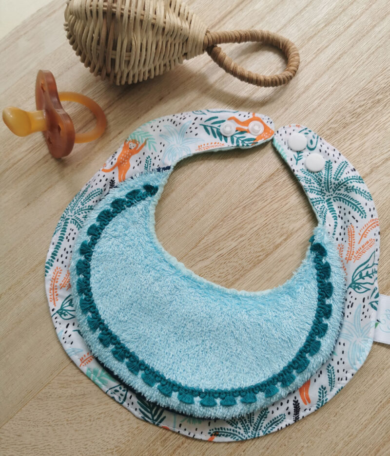 bavoir anti bave pour bébé, hyper absorbant, idéla pour les poussées dentaires, bleu et orange sur motif de jungle fabriqué à la main de manière artisanale, made in france, made in cantal, une création 2 pommes et un mammouth