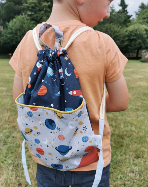 sac à dos ficelle pour enfant fabriqué à la main de façon artisanale, made in france, à motifs cosmiques parsemé d'étoiles et de planètes , une création 2pommes et un mammouth