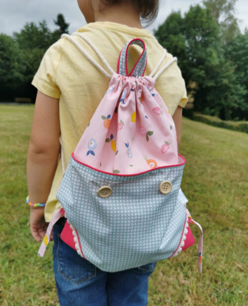 sac à dos ficelle pour enfant fabriqué à la main de façon artisanale, made in france, rose et bleu avec des motifs de fruits , une création 2pommes et un mammouth