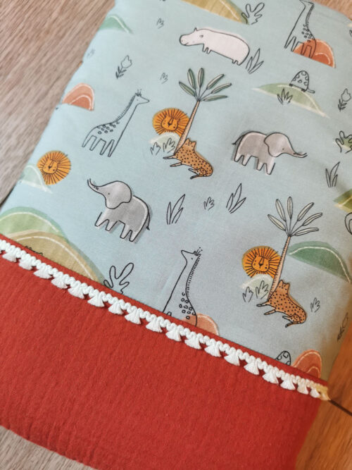 couverture de naissance pour bébé, idéale pour l'été grâce à sa gaze de coton terracota, en coton bio bleu avec des animaux de la savane, fabriqué de la main de manière artisanale à la main, made in france, une création 2 pommes et un mammouth