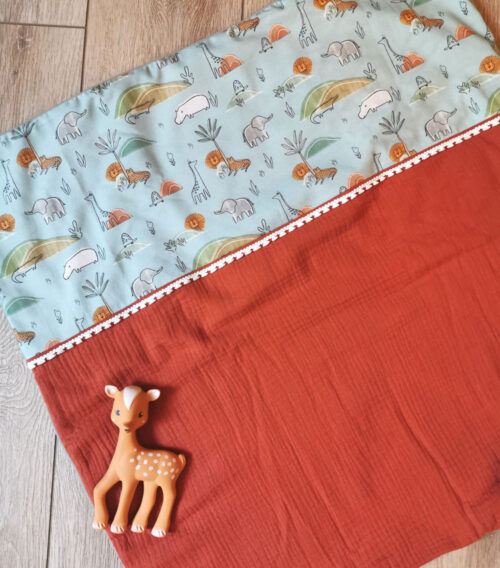 couverture de naissance pour bébé, idéale pour l'été grâce à sa gaze de coton terracota, en coton bio bleu avec des animaux de la savane, fabriqué de la main de manière artisanale à la main, made in france, une création 2 pommes et un mammouth