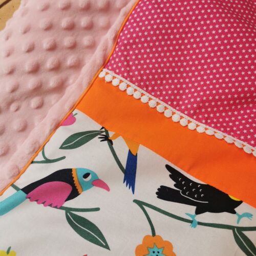 couverture enfant douillette et doublée minky à pois, fabriquée à la main, made in France, artisanat, fabriquée dans le cantal. une bonne idée de cadeau de naissance ou de cadeau d'anniversaire pour un enfant. couverture pour petite fille rose et orange avec des oiseaux colorés.